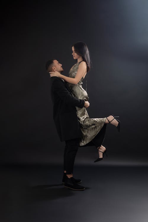 A man and woman are standing in front of a black background
