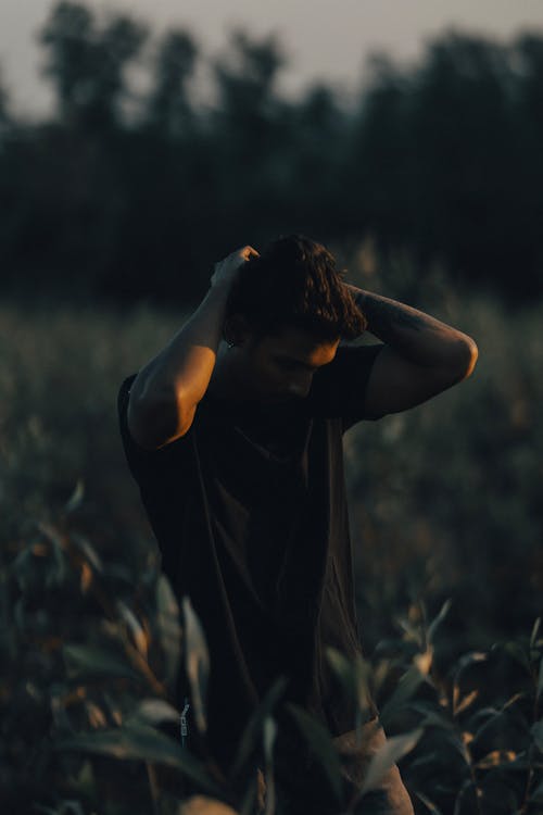 A Man in a Black T-shirt Standing on a Field