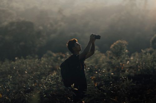 Free Silhouette of a photographer capturing the scenic meadow during the golden hour. Stock Photo