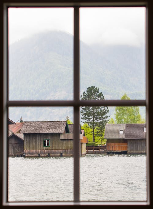 A window with a view of a lake and houses