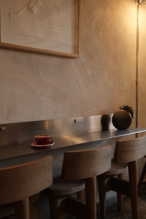 A counter with two stools and a coffee cup on it