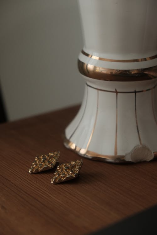 Golden Earrings Next to a Vase 