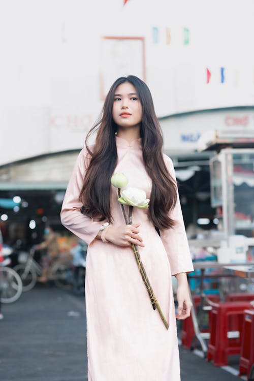 Asyalı kadın, ayakta, Çiçekler içeren Ücretsiz stok fotoğraf