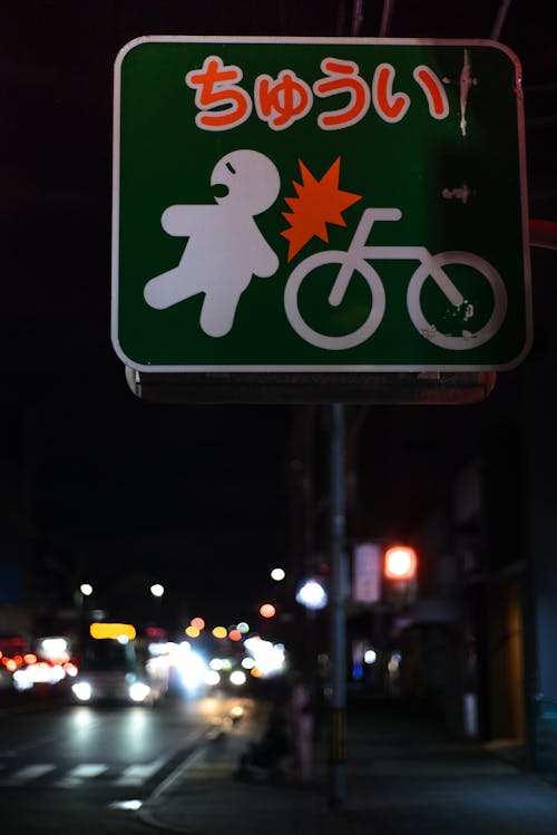 Close-up of a Caution Sign in Japanese on a Street in City at Night 