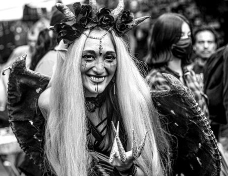 A striking black and white portrait of a costumed woman on the street, showcasing traditional culture.