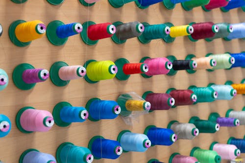 Close-up of Colorful Thread Spools on a Wall 