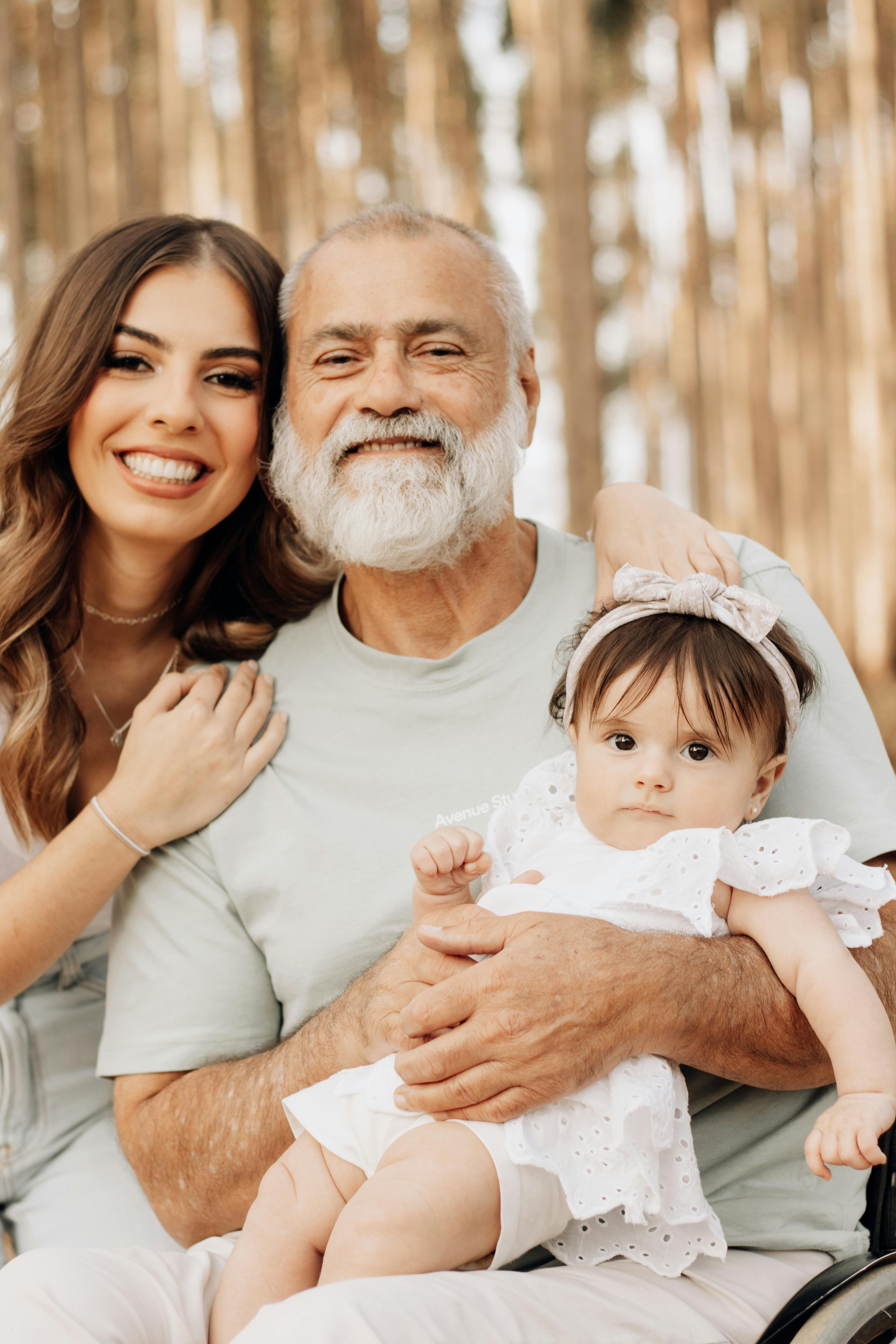 Cheerful grandfather with daughter and granddaughter enjoying a day in the park.