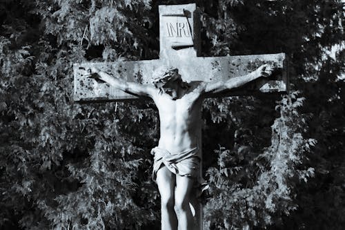 A black and white photo of a cross with jesus on it