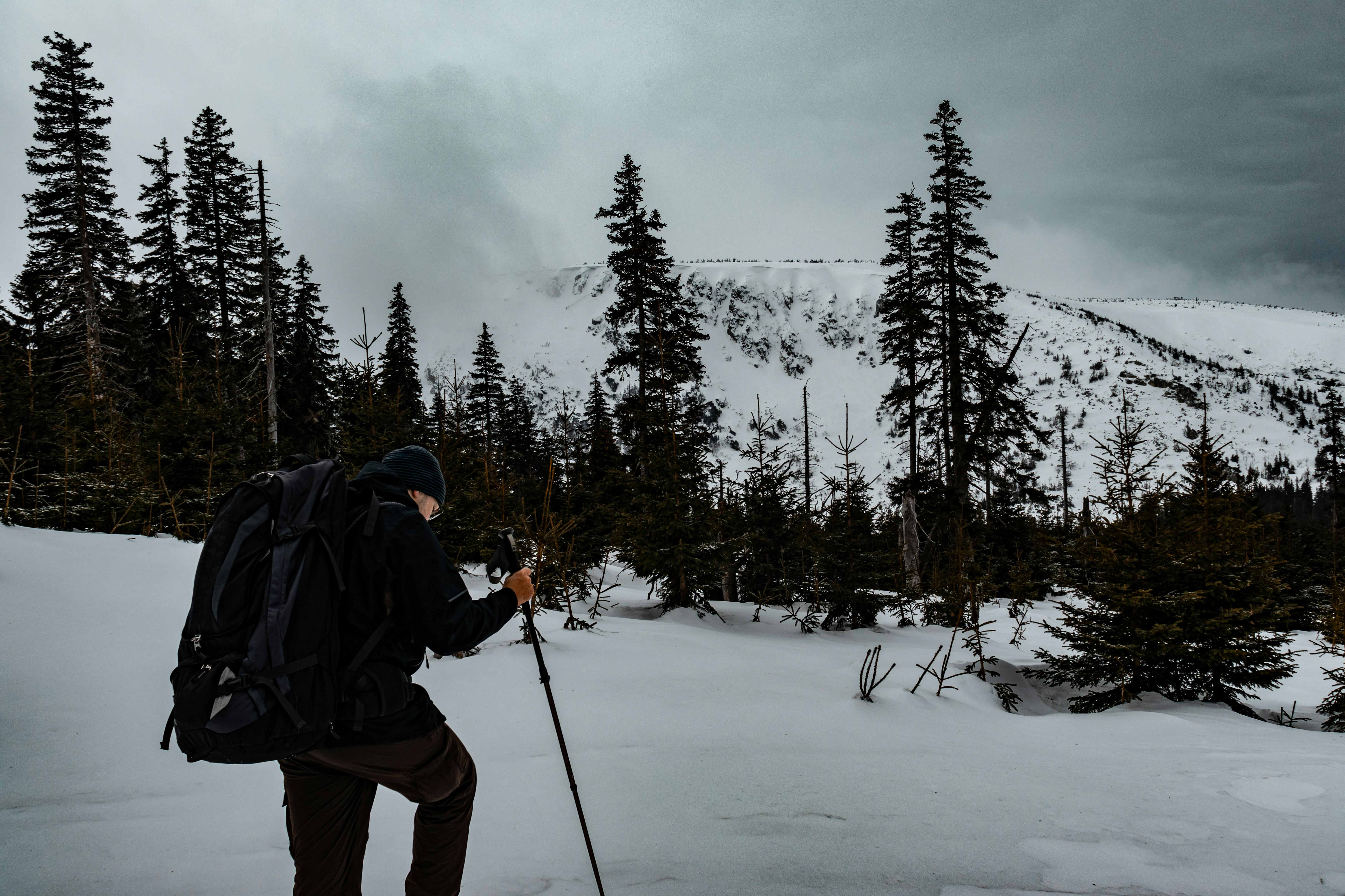 A hiker explores the snowy landscape of Karkonosze, Poland, during winter.
