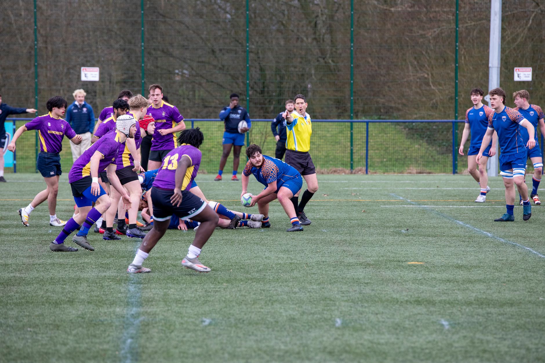 Players engage in a dynamic rugby match, showcasing athleticism and teamwork on a grass field.