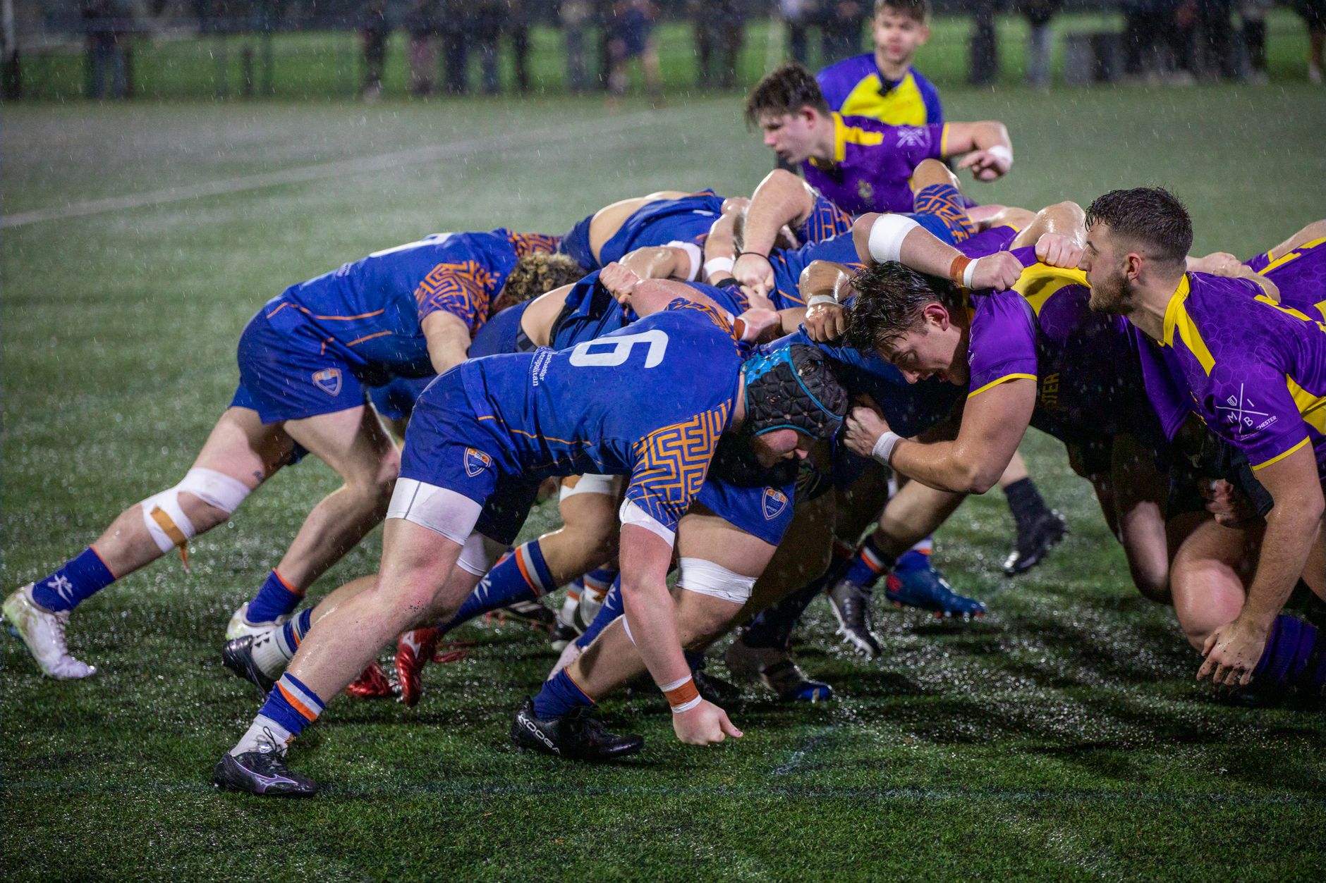 A dynamic rugby scrummage during a match in Manchester, England.