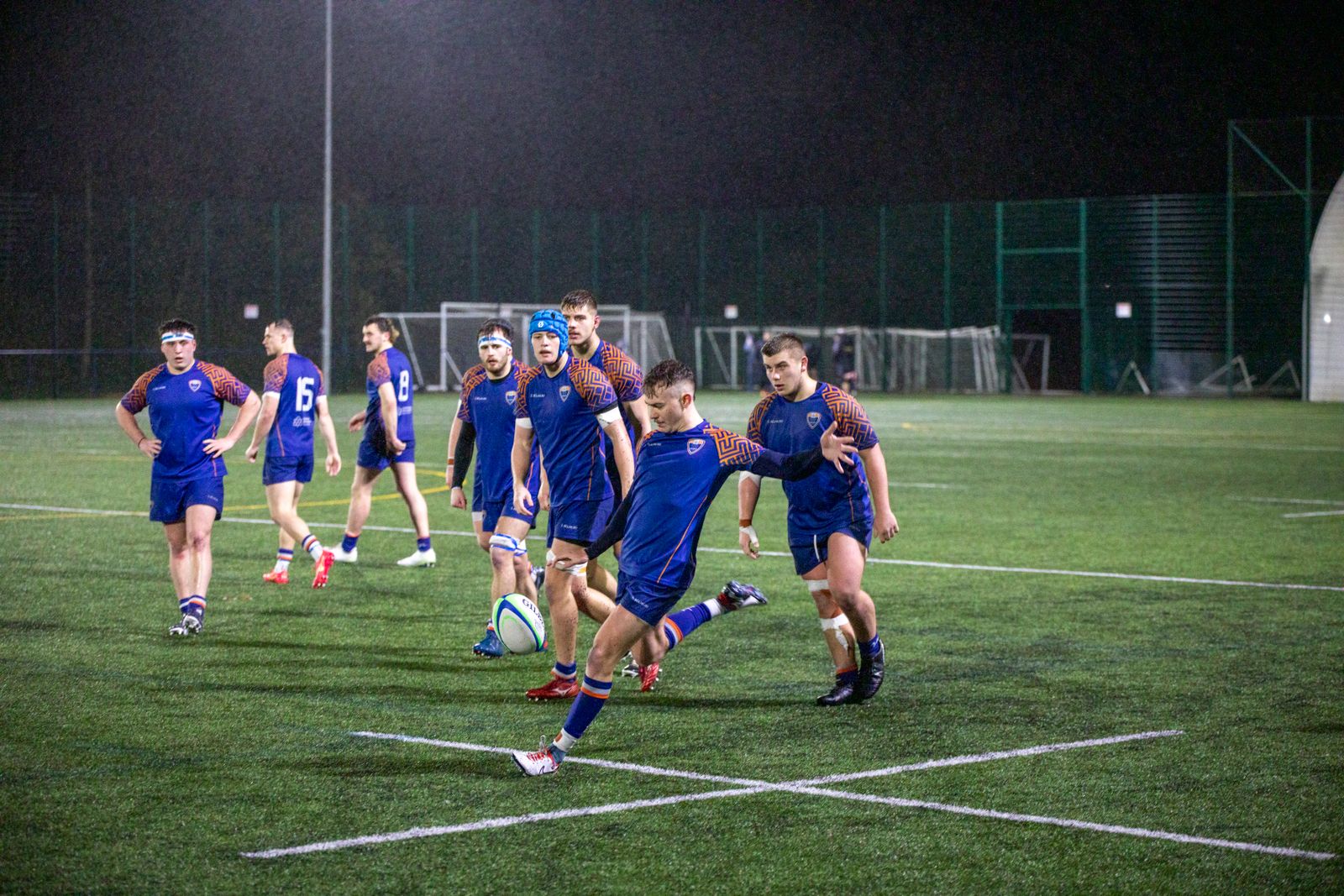 Rugby players training under stadium lights