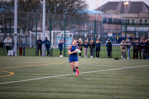 A woman running on a field with a ball