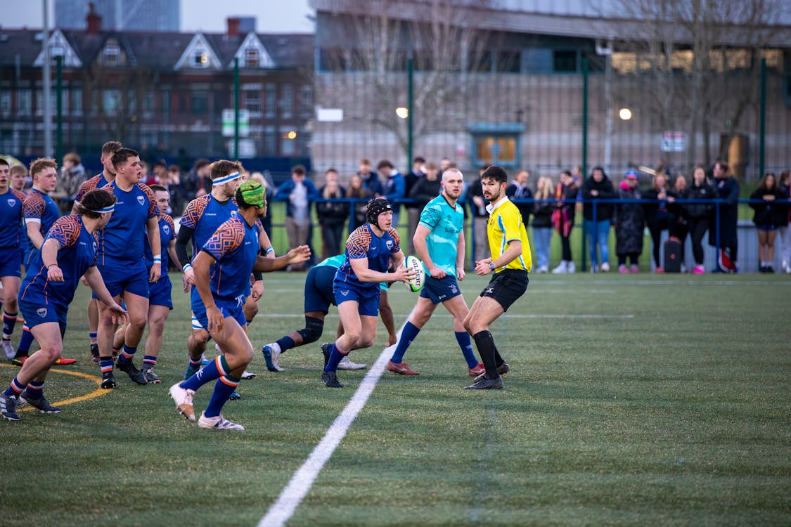 A group of men playing a game of rugby on a field