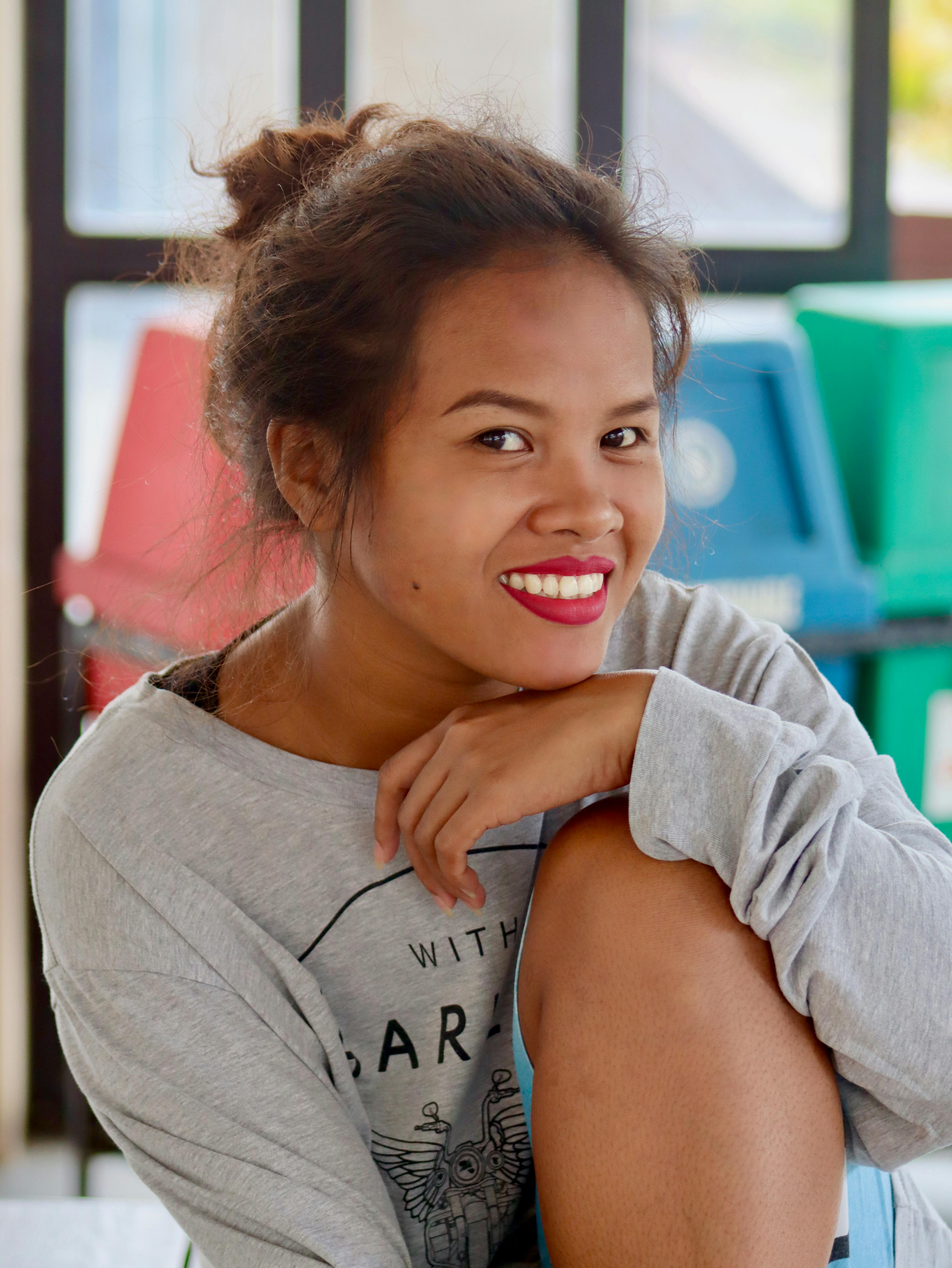 Young woman smiling indoors, wearing a grey sweatshirt in Cebu City, Philippines.