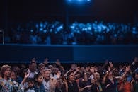 一群不同的人在室内礼拜场所举手