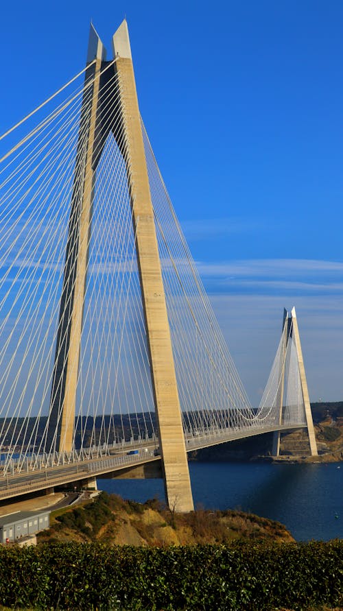 A large bridge with a blue sky and water