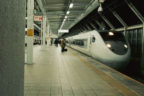 Free A modern train at a Japanese station with passengers on the platform at night. Stock Photo