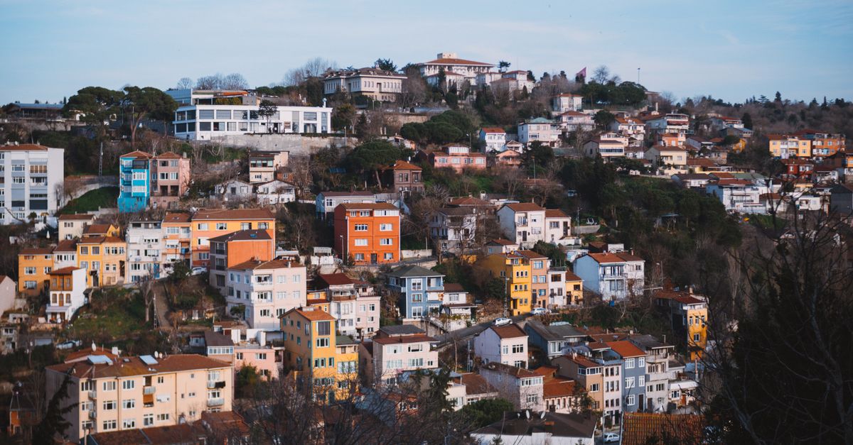 A vibrant hillside town with colorful houses and lush greenery, captured in daylight.