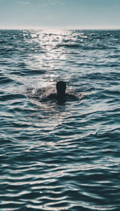 A person swimming in the ocean surrounded