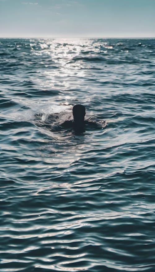 A person swimming in the ocean surrounded