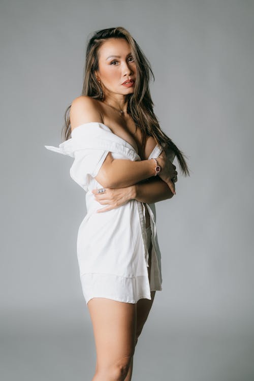 A woman in a white shirt and shorts posing