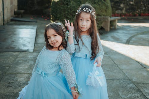 Two little girls dressed in blue dresses