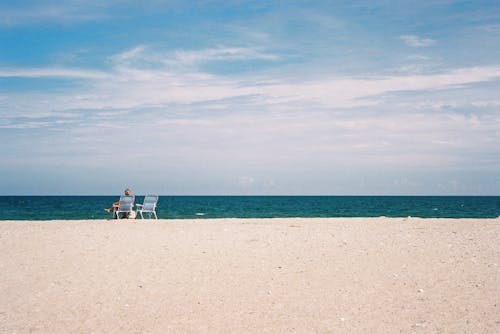 Woman on Sunbeds on Beach in Summer