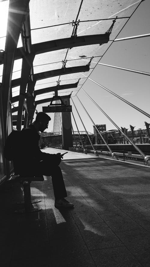 Man Sitting at Halic Bridge Metro Station in Black and White