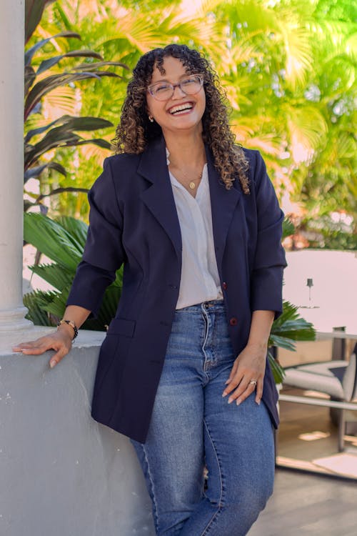 A woman in jeans and a blazer smiling