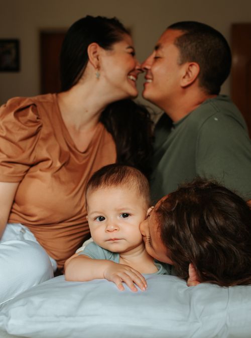 Free A joyful family moment captured at home with parents and children embracing and smiling. Stock Photo
