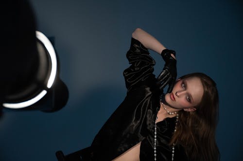 Model in a Satin Black Blouse and Leather Gloves Posing in the Studio