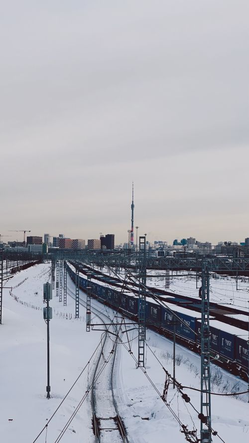Free Freight train travels through snowy Moscow with skyline view in winter. Stock Photo