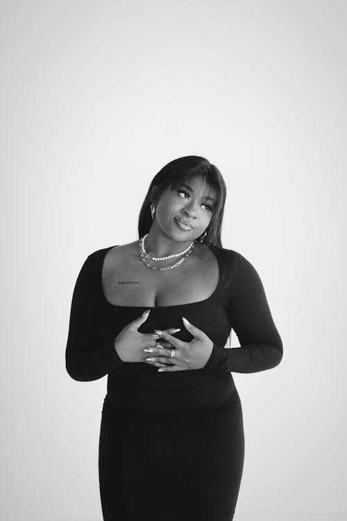 A black and white photo of a woman in a black dress