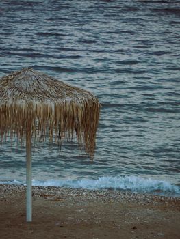 Peaceful beach scene with straw umbrella by the sea in Alexandroupoli, Greece.