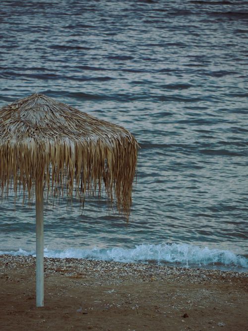 Free Peaceful beach scene with straw umbrella by the sea in Alexandroupoli, Greece. Stock Photo