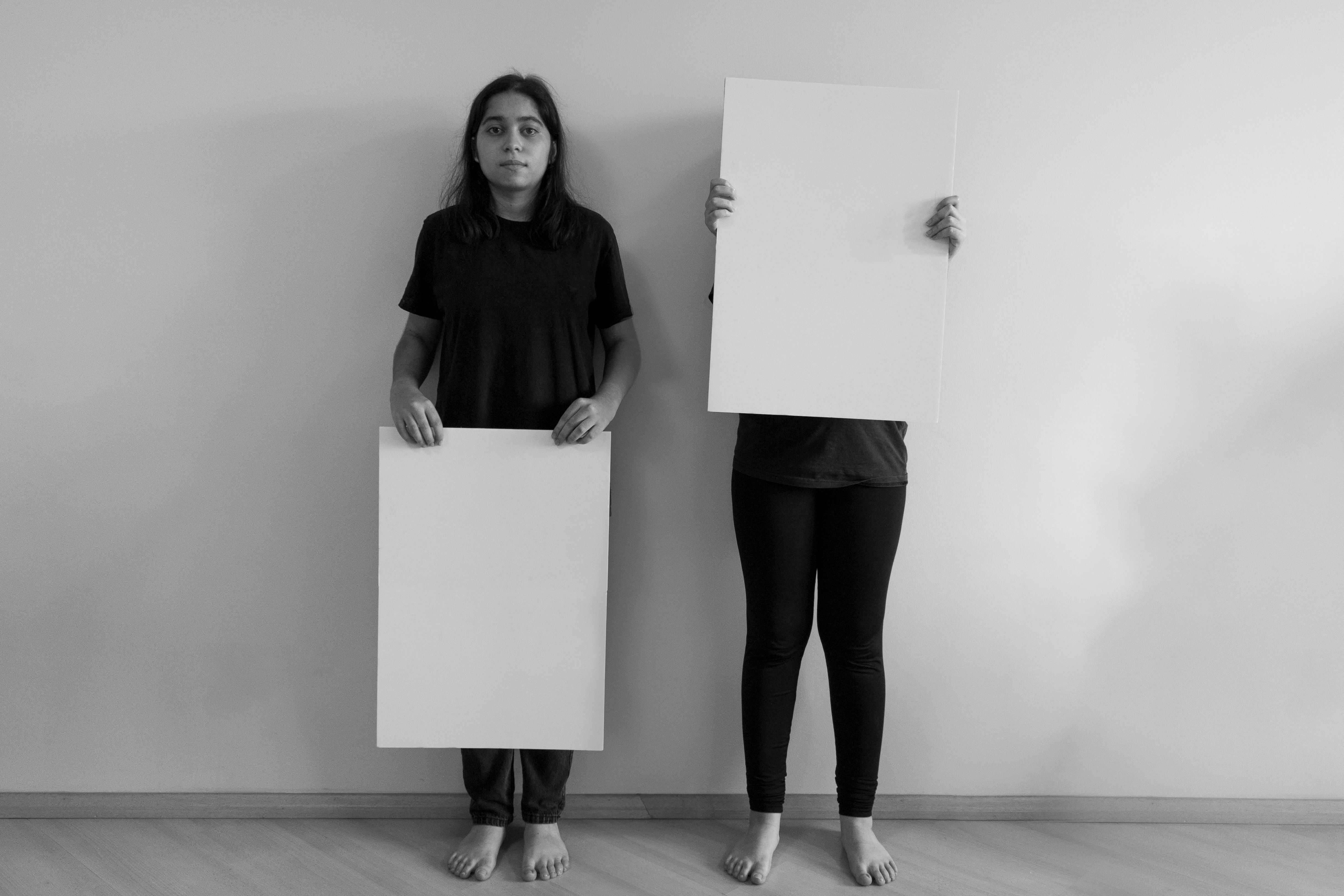Women Standing with Cardboard Boards in Black and White · Free Stock Photo
