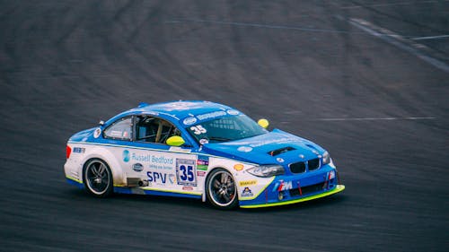 A blue and white race car driving on a track
