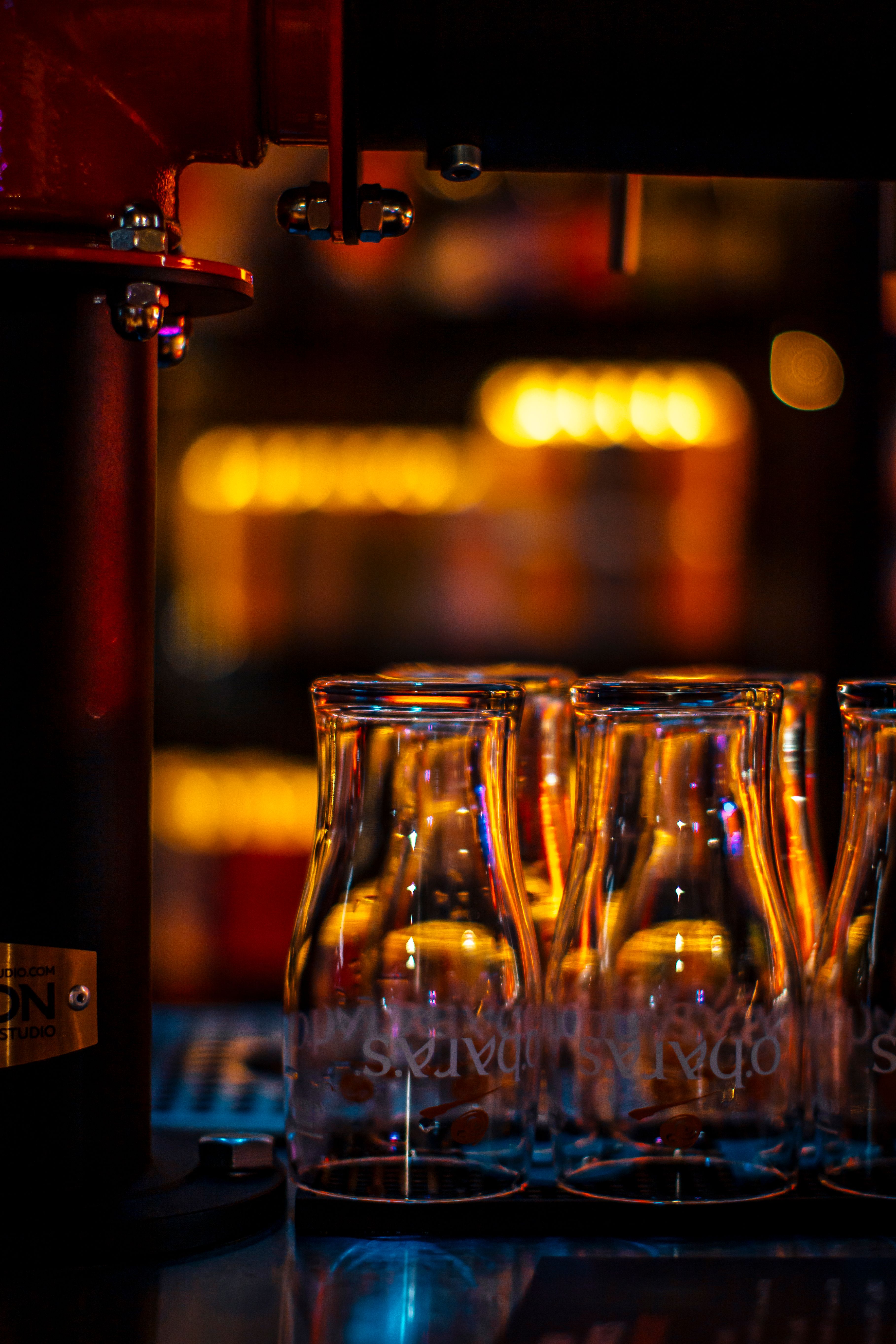 Elegant close-up of empty glasses in a warm and vibrant bar atmosphere.
