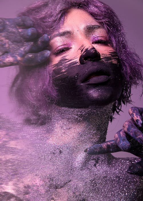 Artistic Studio Shot of a Woman with Painted Face and Purple Hair