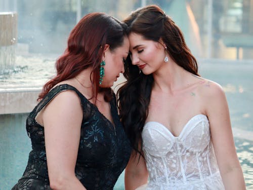 Two women in wedding dresses hugging each other