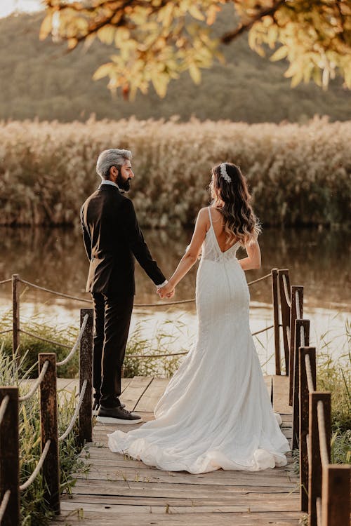 Newlyweds Standing on Wooden Boardwalk on Lake