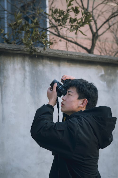 Man in Jacket Taking Pictures with Camera
