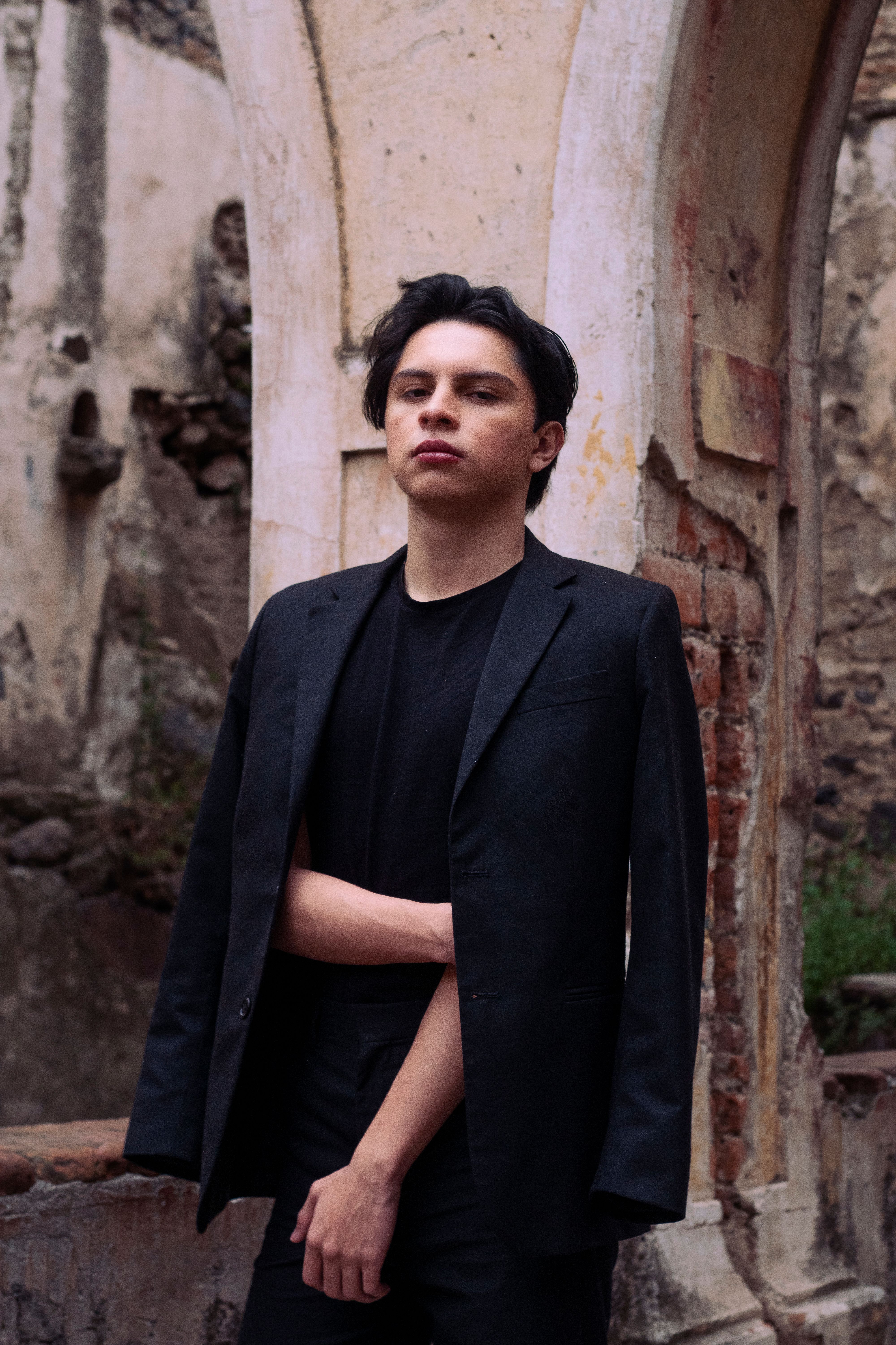 Portrait of a Hispanic teenager in a black suit jacket in a historic urban setting in Texcoco, Mexico.