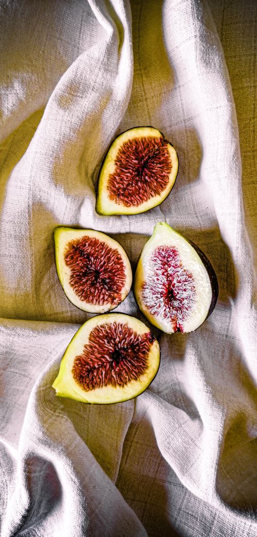 Figs and leaves on a table with a plant · Free Stock Photo