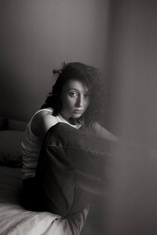 Free Artistic black and white portrait of a woman sitting with contemplative expression. Stock Photo