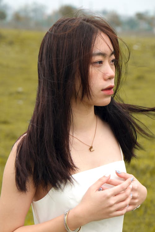 A woman with long hair standing in a field