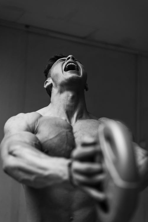 Shirtless Man Lifting Weights and Screaming 