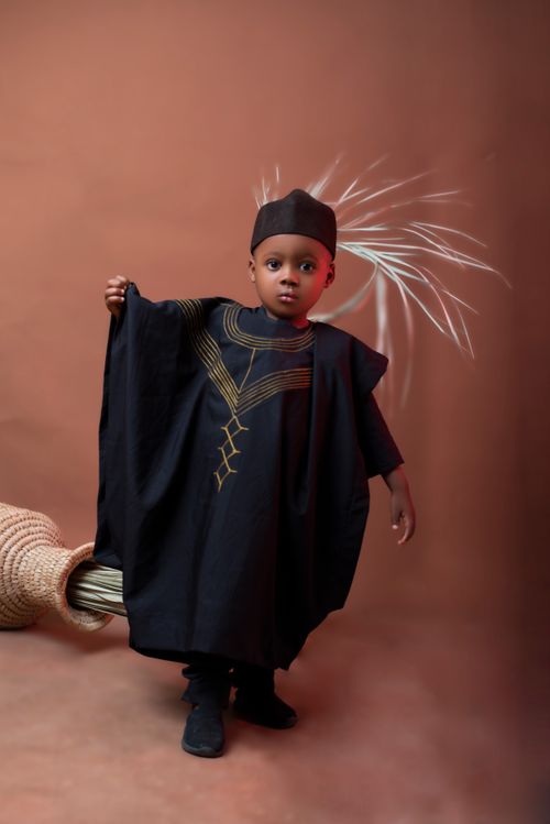 Free A young boy poses confidently in traditional African clothing in a studio setting. Stock Photo