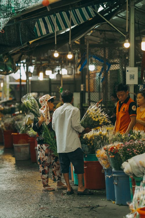 People are shopping at a market with flowers